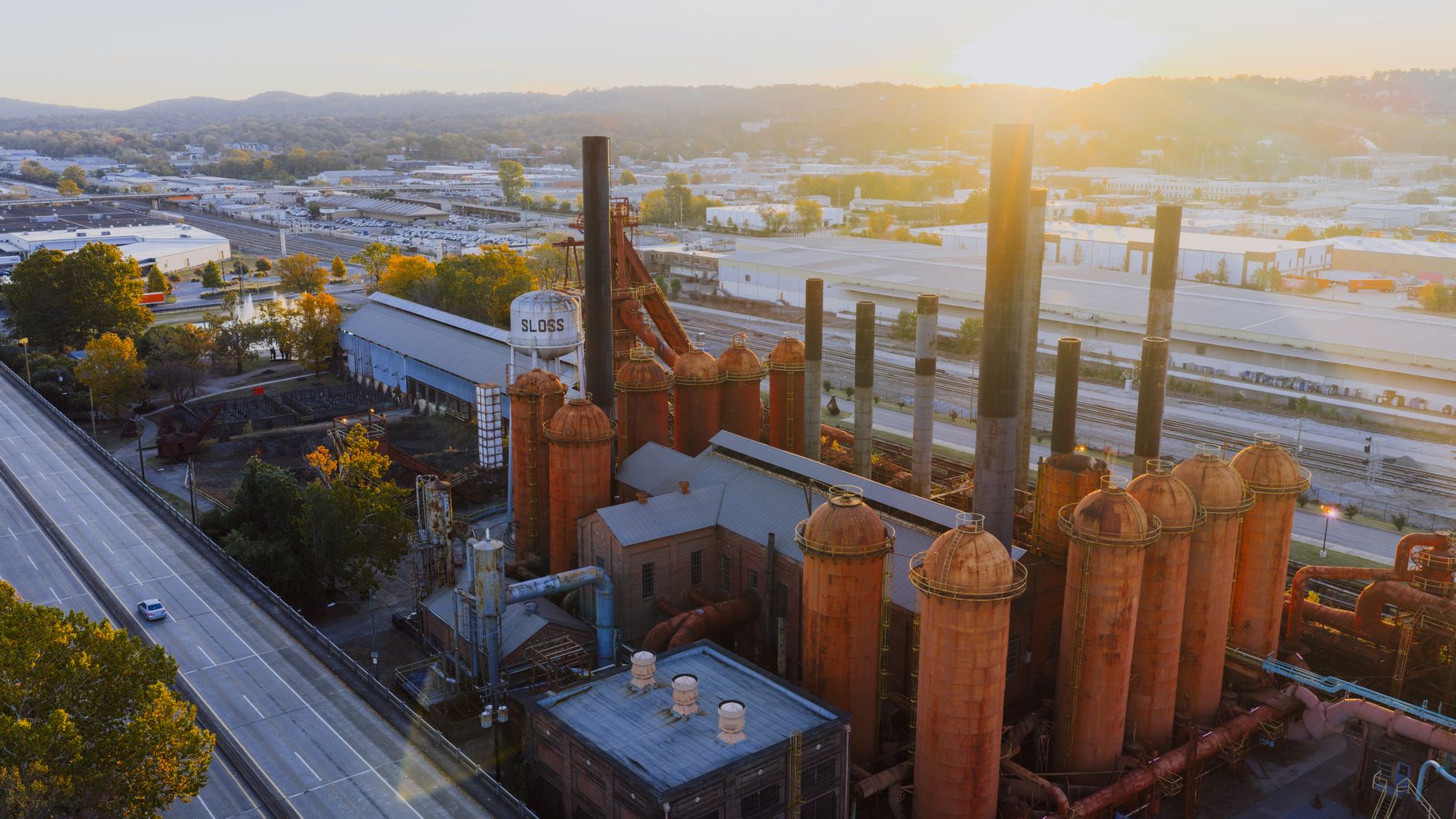Sweeping view of diverse American landscapes, from historic industrial sites to vast natural features, symbolizing ingenuity and innovation.