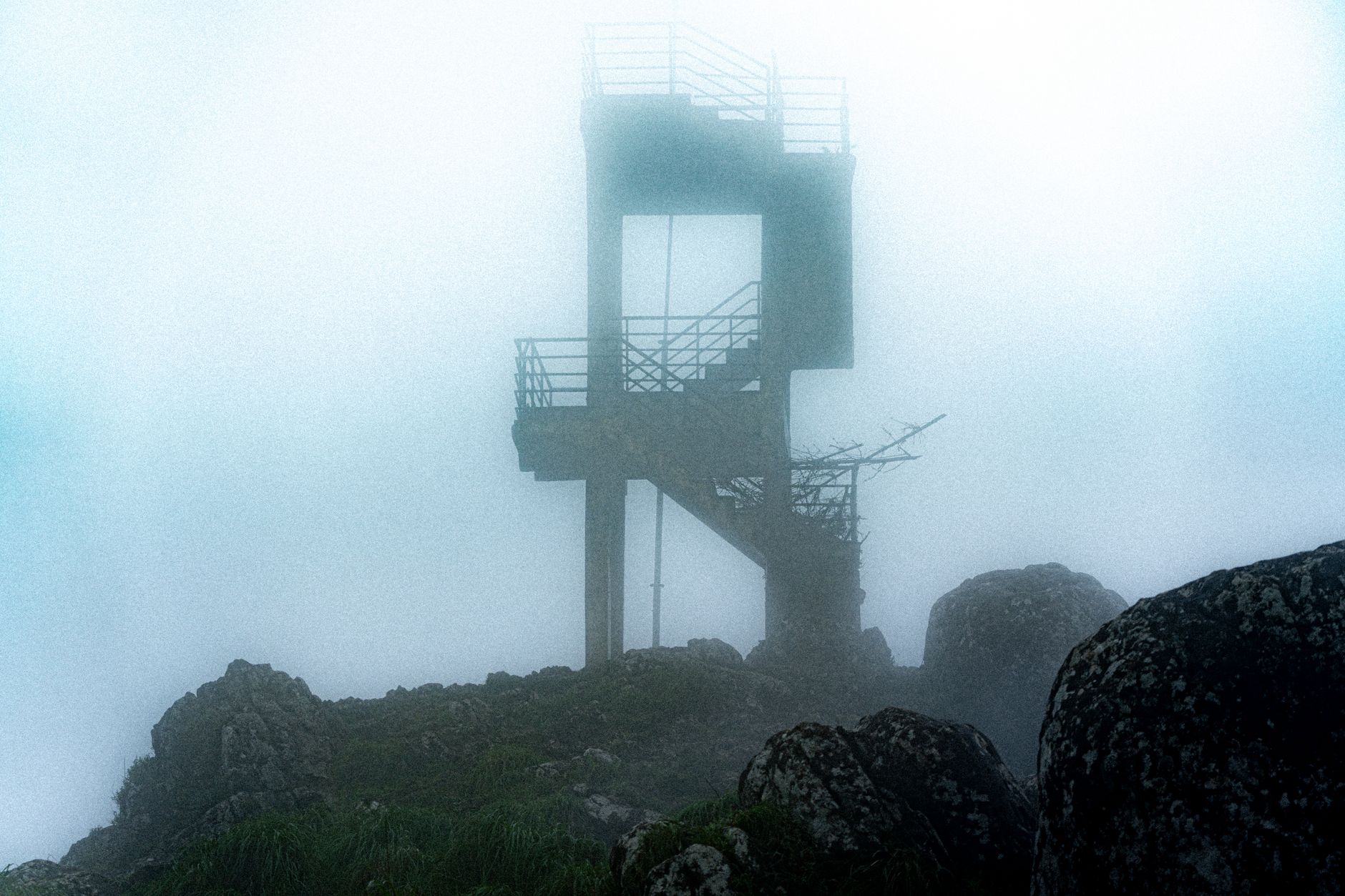 A sweeping, atmospheric landscape showing ancient, mysterious ruins partially obscured by mist at dawn, evoking a sense of hidden history and forgotten stories.