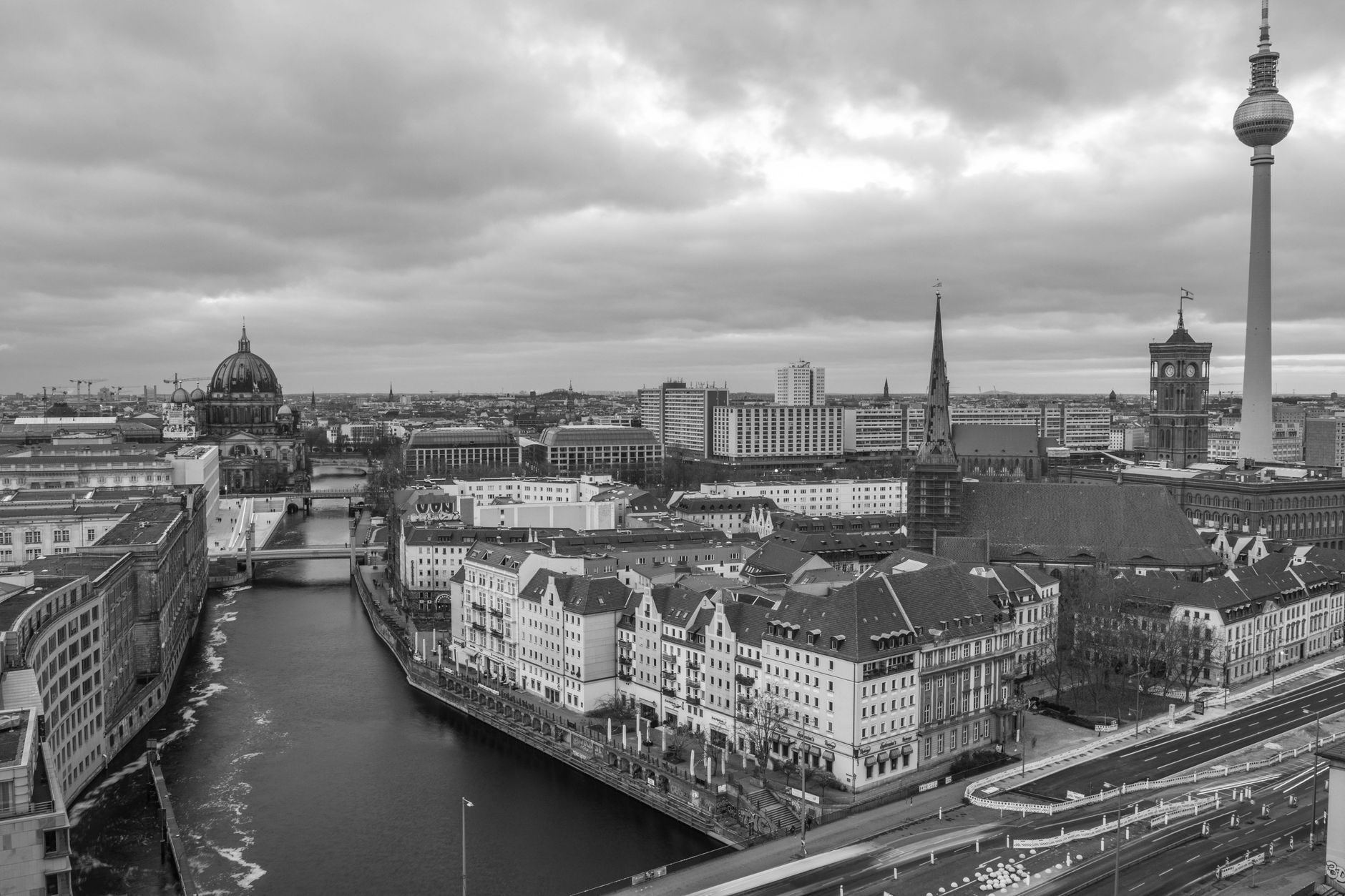 A wide-angle view of Berlin's diverse architecture, blending historic buildings with modern structures under a cloudy sky.