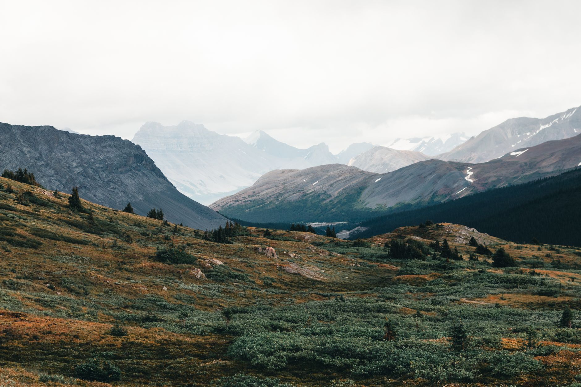 Sweeping vista of a remote, rugged national park with dramatic geological features under a vast sky, evoking a sense of discovery.