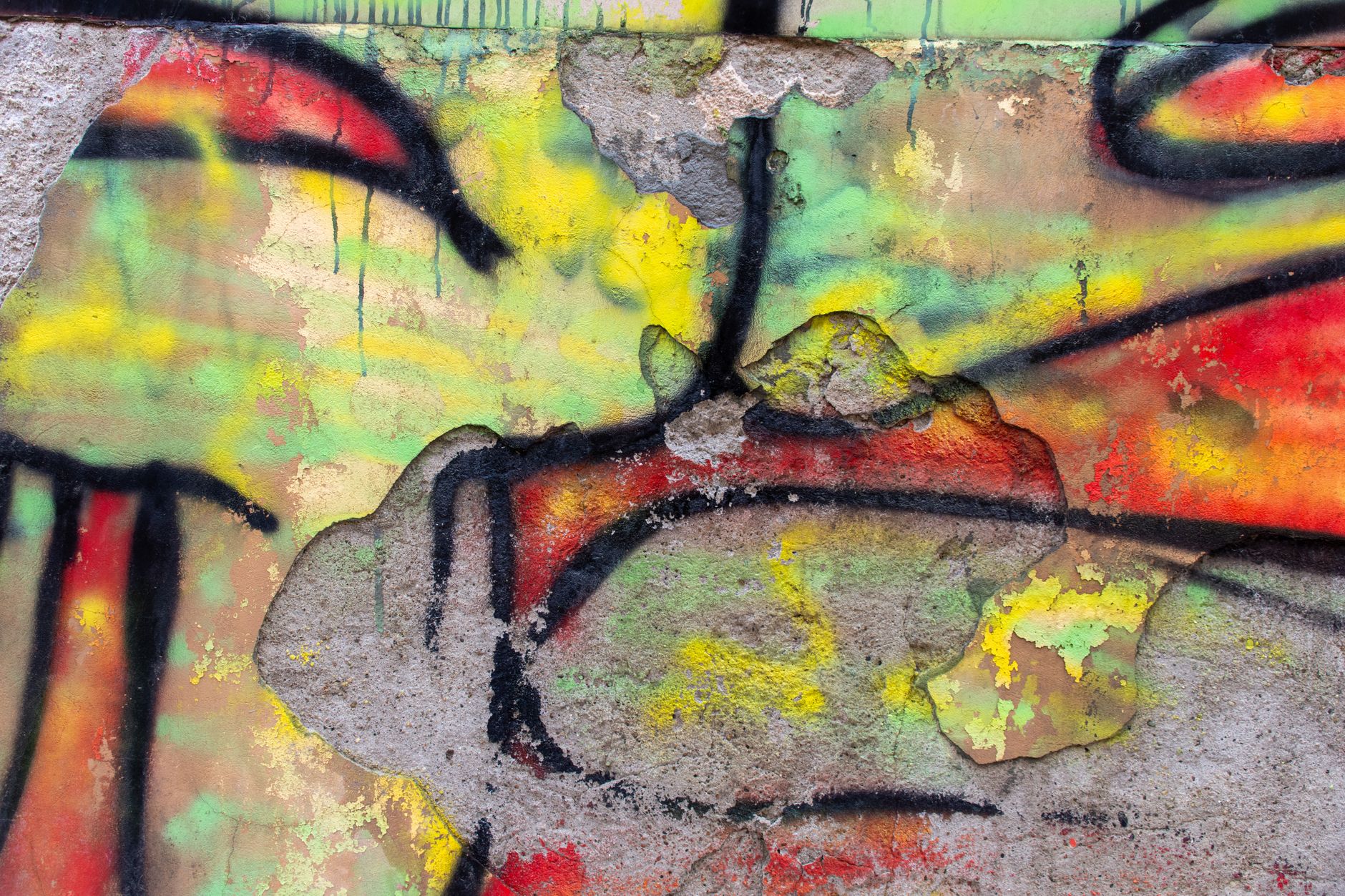 A vibrant street art mural covering a historic building in a bustling Madrid neighborhood, with people walking by.