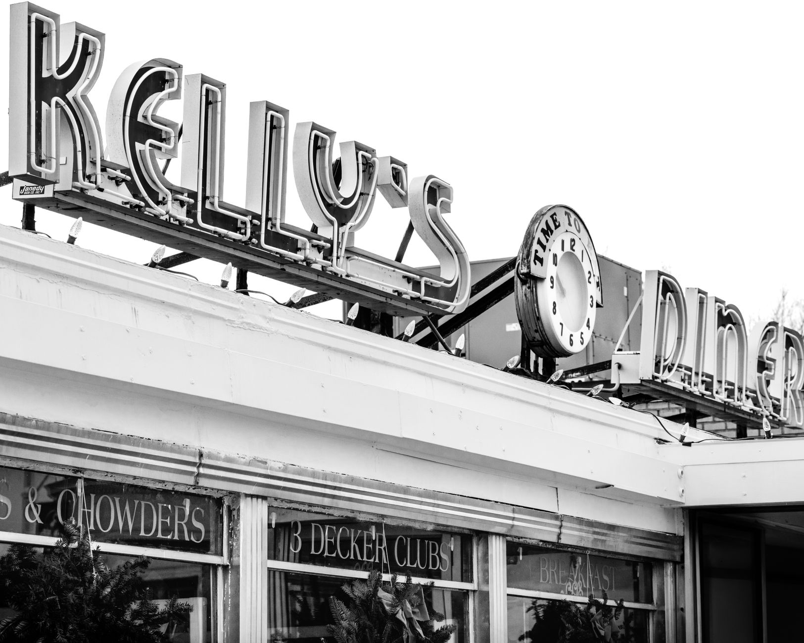 A classic American diner sign in a small town at dusk, suggesting a hidden gem of a restaurant.