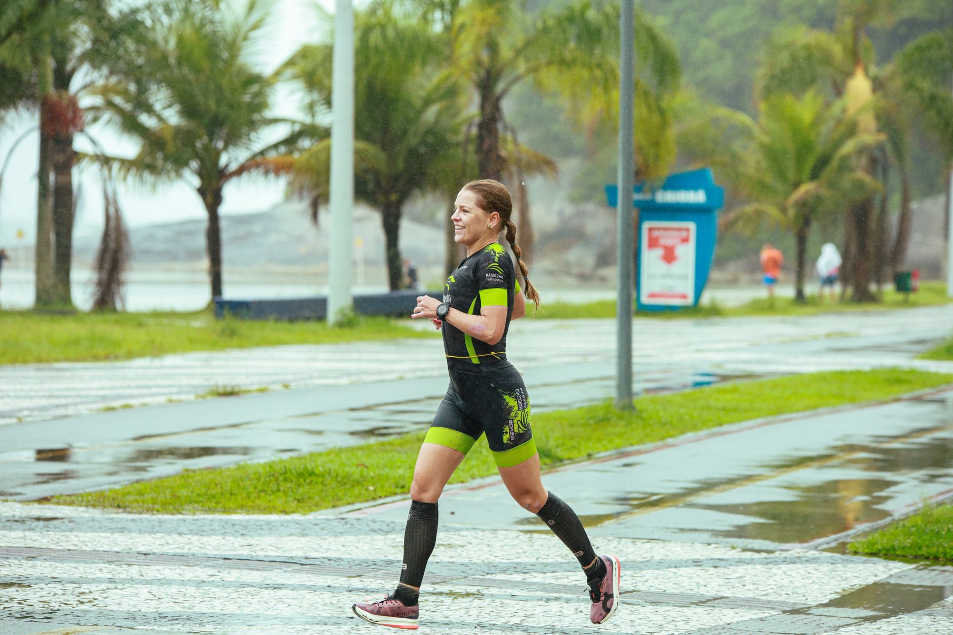 An athlete running with focus through a misty, rain-soaked mountain trail, highlighting resilience in challenging weather.