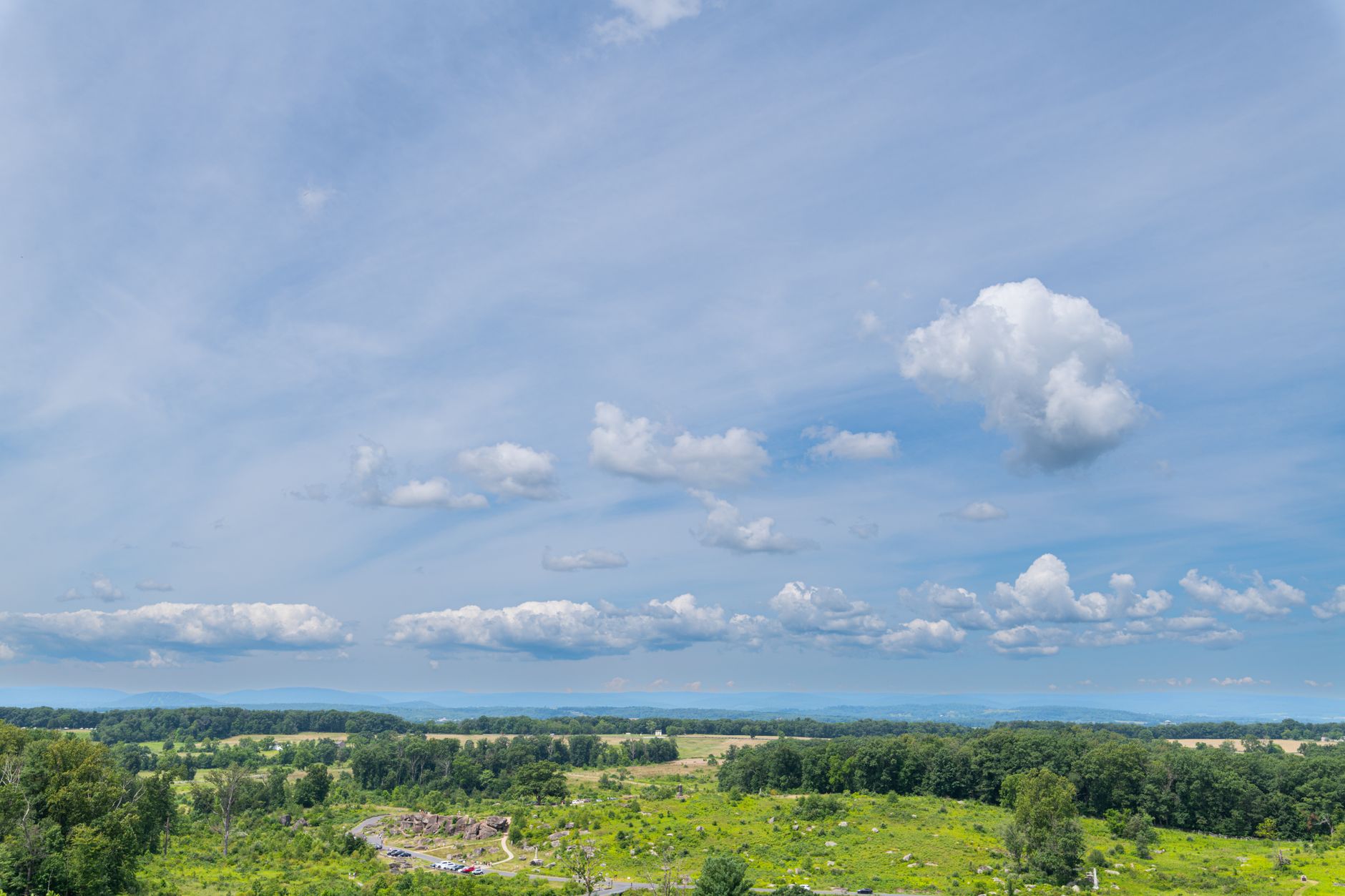 A sweeping view of varied American landscapes, from industrial heritage sites to open plains, hinting at diverse histories.