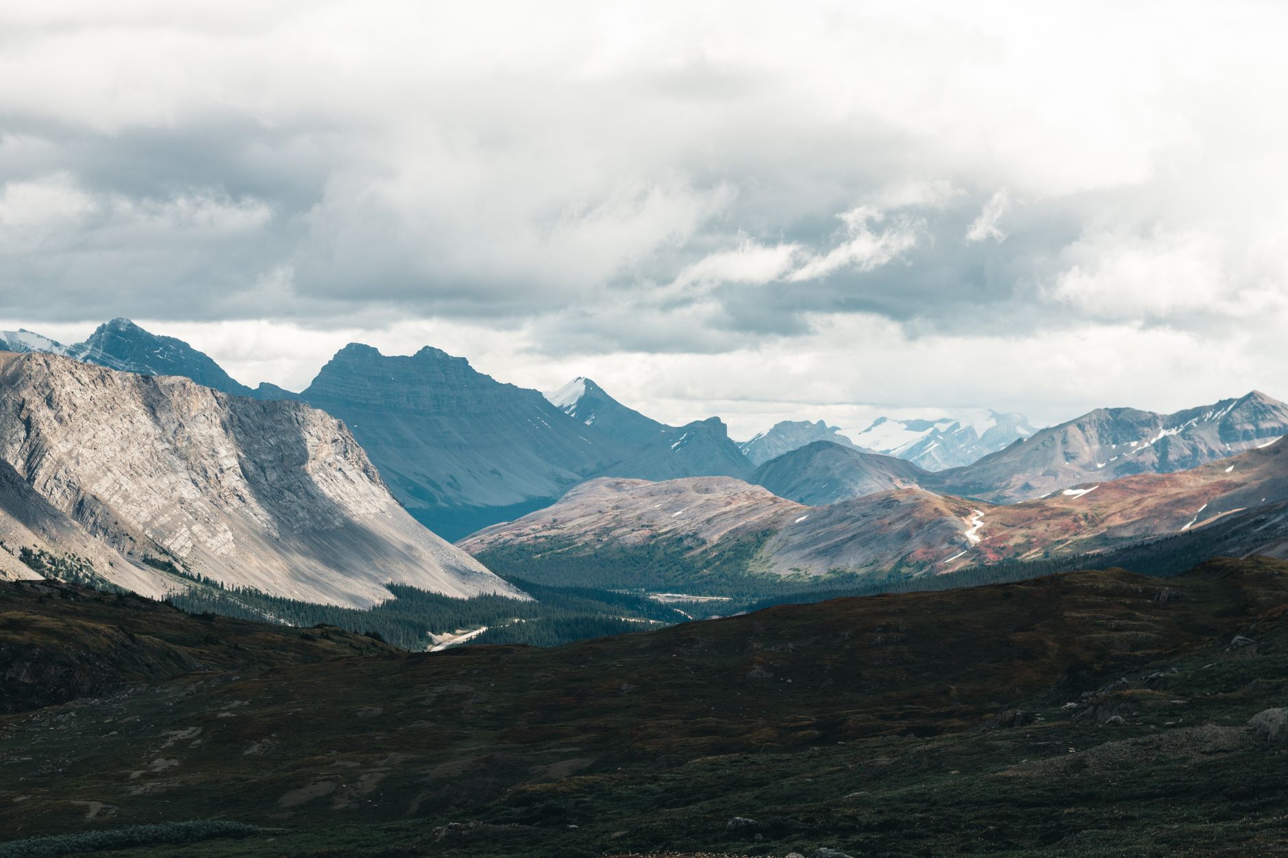 Sweeping panoramic view of a vast, tranquil Canadian wilderness under a clear sky, hinting at unexplored natural beauty.