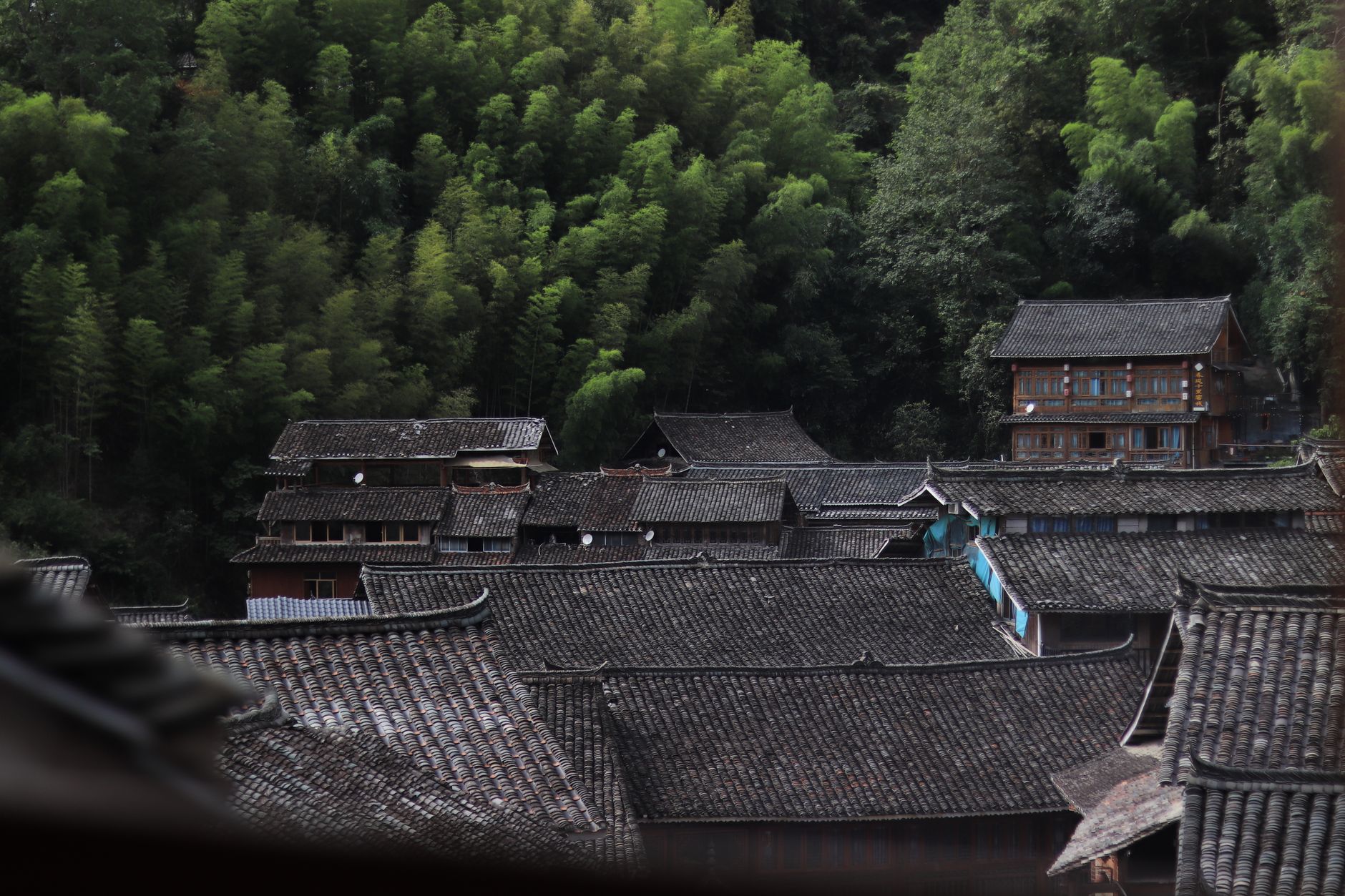 A sweeping view of a quiet, ancient village built into a rocky hillside, with winding paths and historic architecture under a clear sky.