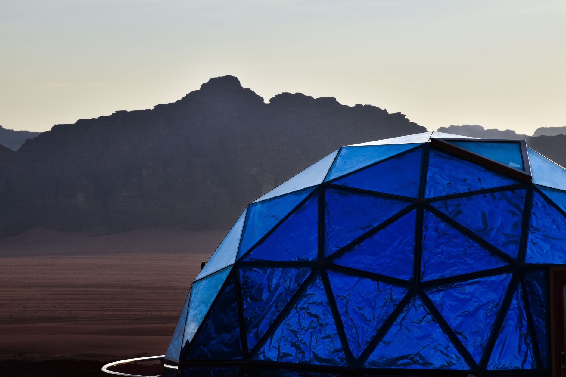 A lone Bedouin tent stands against a sweeping desert landscape at sunrise, evoking ancient traditions and vastness.