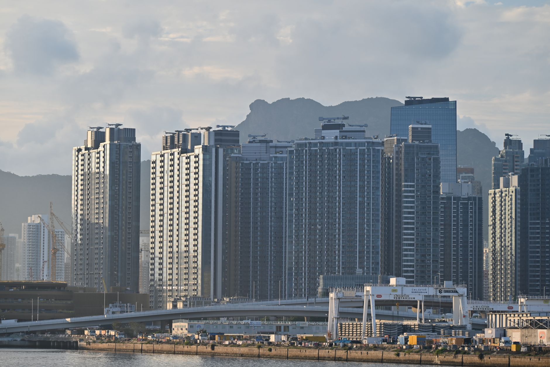 A panoramic view showcasing a blend of traditional Chinese architecture and modern cityscapes in Macau and Hong Kong, hinting at historical depth.