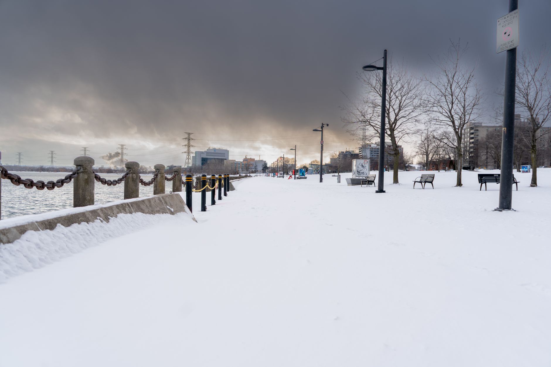 A serene winter scene along the shores of Lake Ontario near Hamilton, with minimal snow and a hint of open water, suggesting milder temperatures.