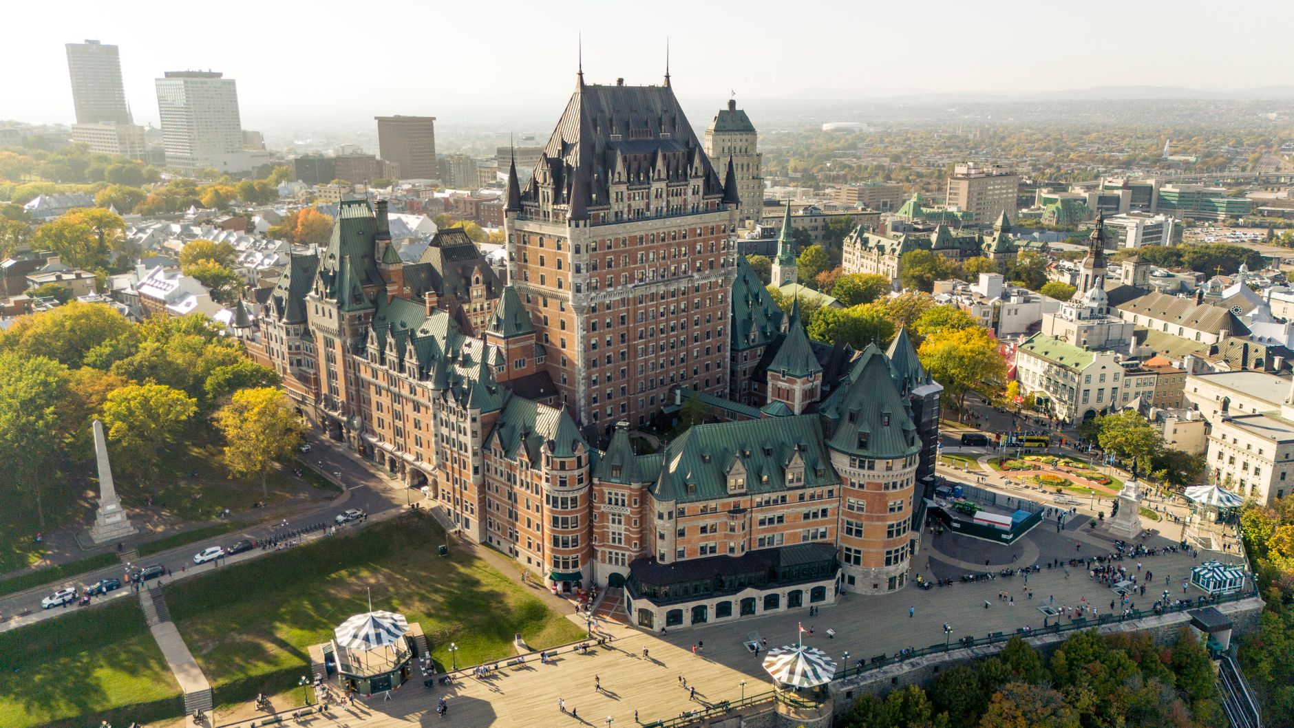 An aerial view of Quebec City, showing the historic fortified walls, the Château Frontenac, and the winding streets of the Old Town against the St. Lawrence River.