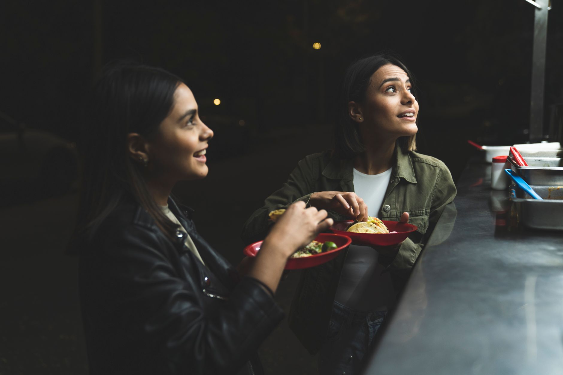 A bustling, vibrant Mexican street market at night, with vendors preparing a variety of colorful street foods, illuminated by warm lights, showcasing the rich culinary scene.