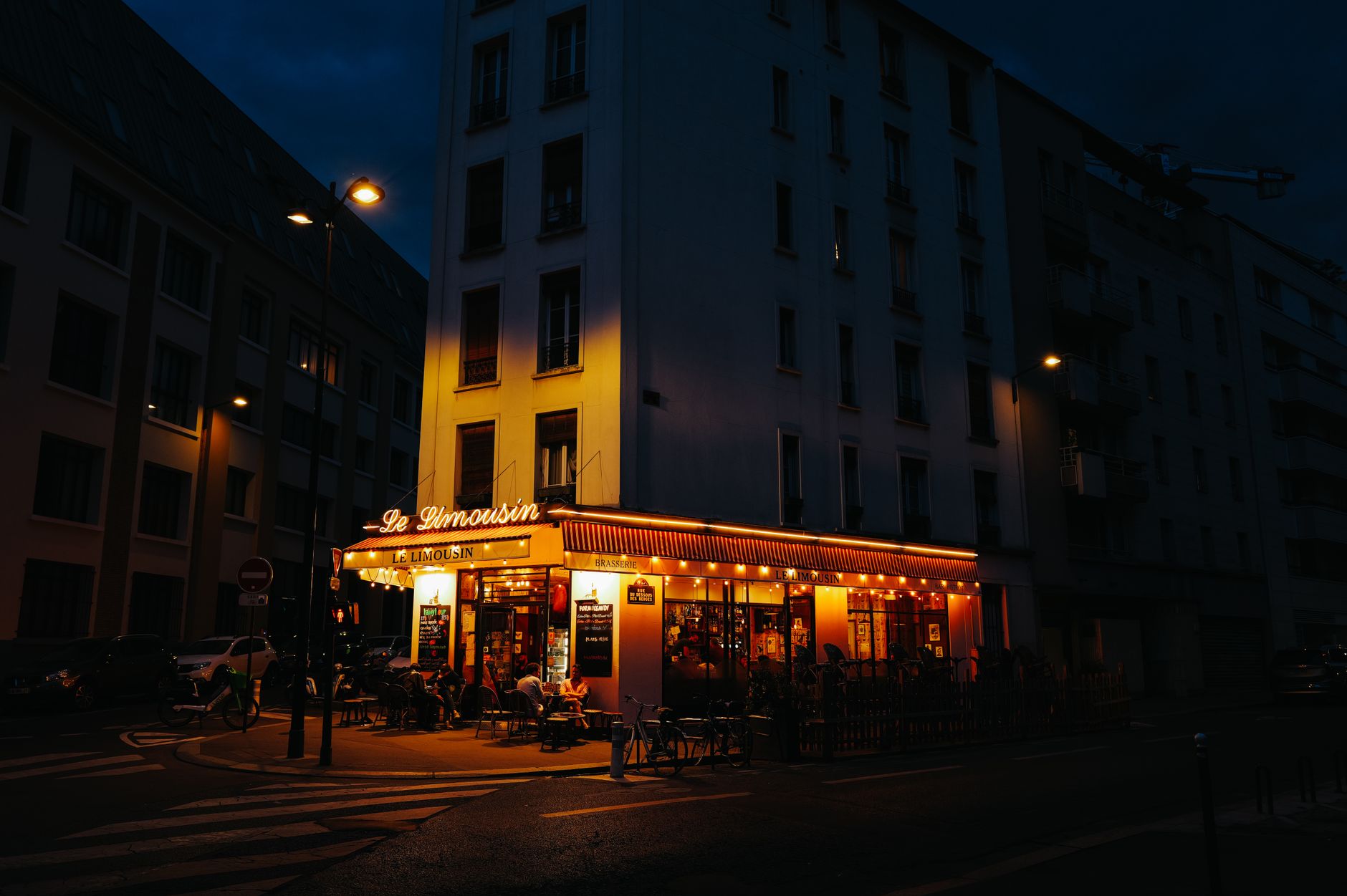 A cozy Parisian bistro bathed in warm autumn light, with golden leaves scattered on the cobblestone street outside.