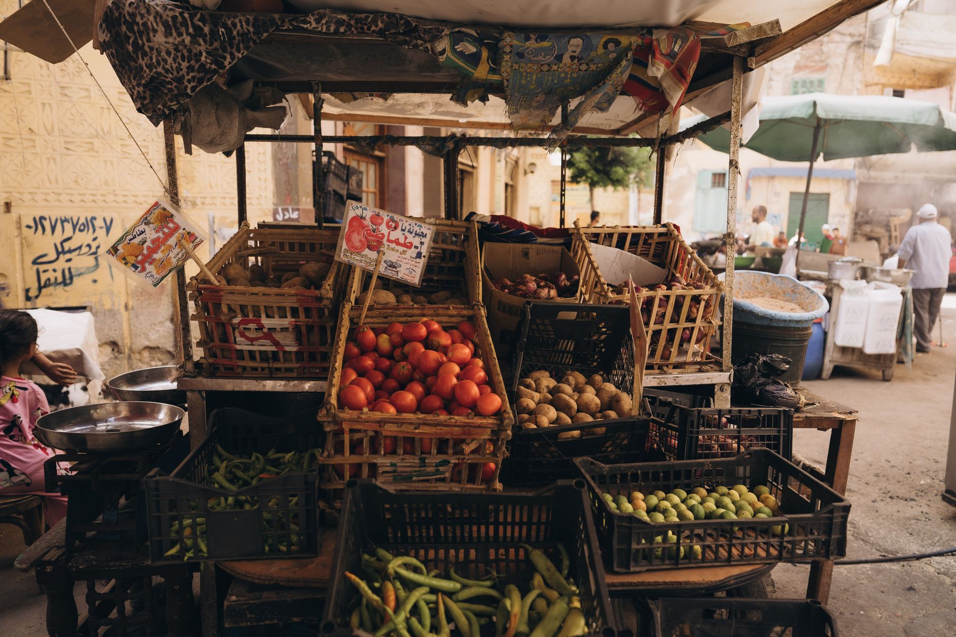 A vibrant, bustling street scene in historic Cairo, showcasing a blend of ancient architecture and modern daily life, with food stalls and people enjoying local food.