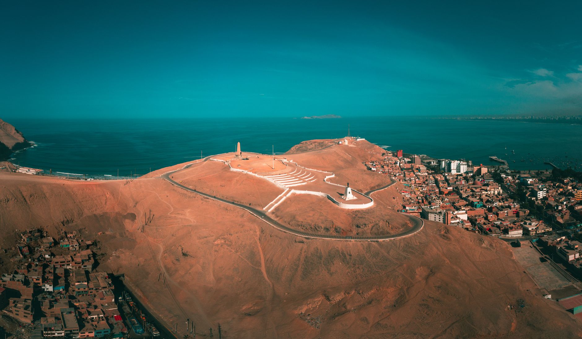 Sweeping aerial view of ancient ruins nestled among dramatic Peruvian mountain ranges and lush valleys
