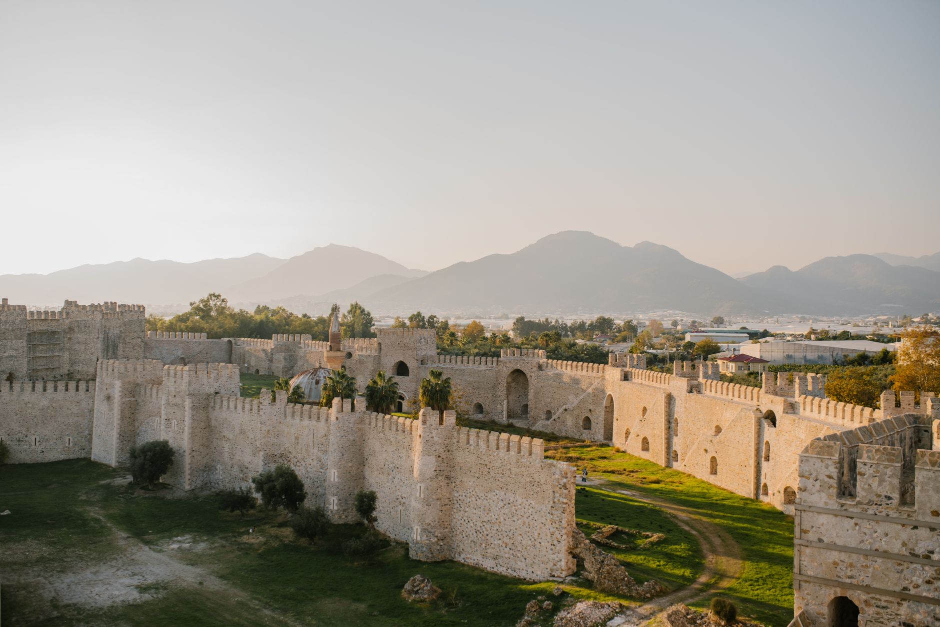 Sweeping panoramic view of an ancient Turkish landscape with rolling hills and distant ruins under a clear, vast sky.