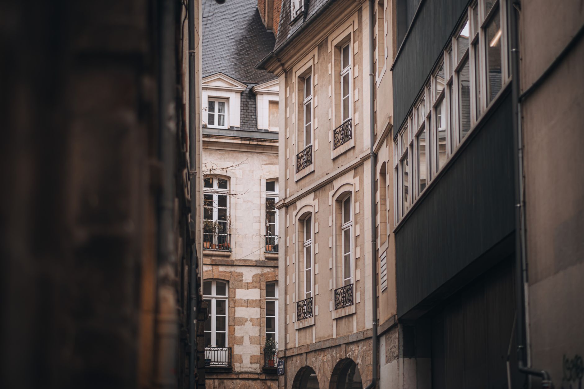 An aerial view of a charming, less-traveled Parisian street, possibly a narrow alley or a hidden courtyard, hinting at the city's secret spots.