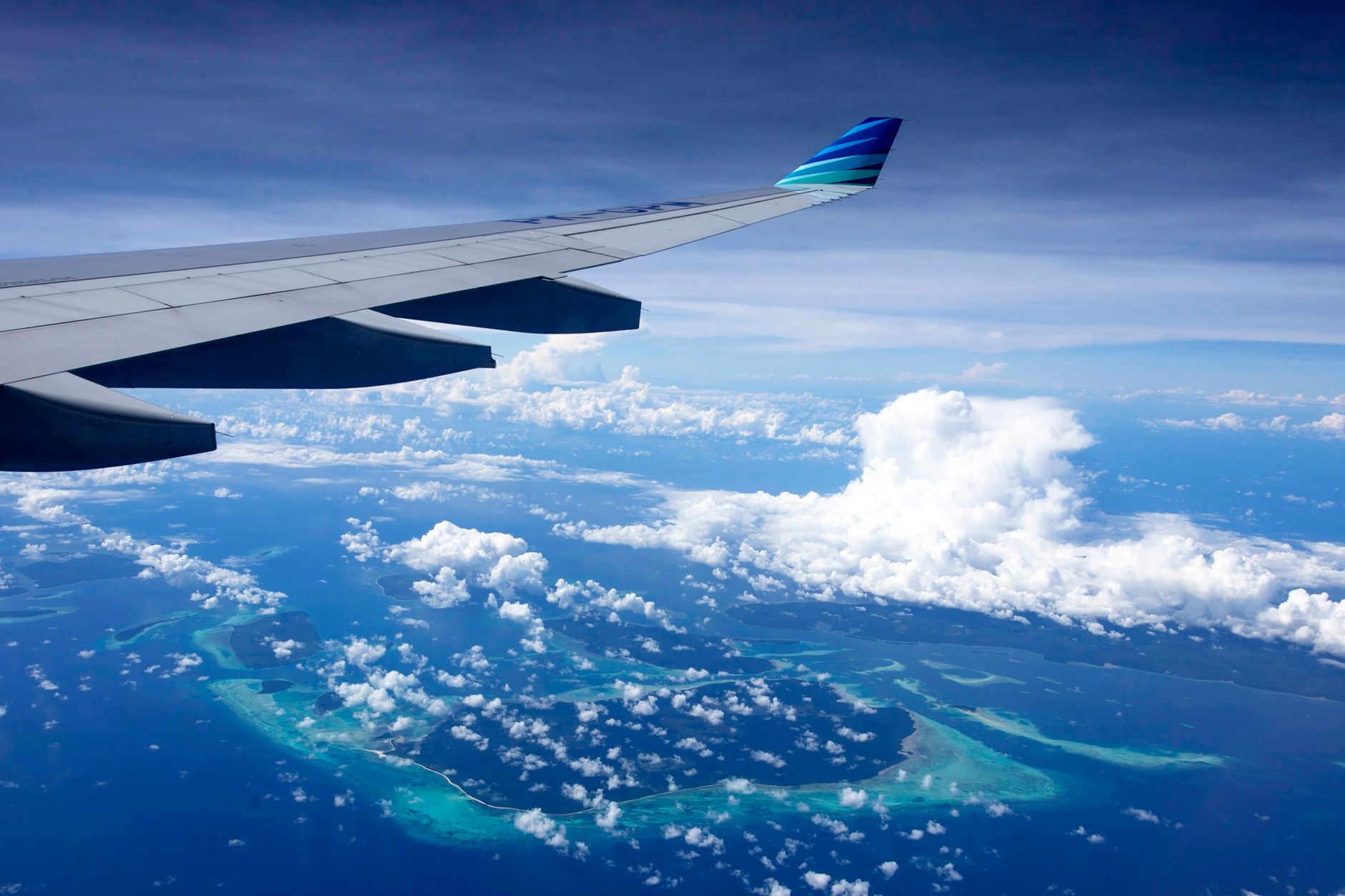 Aerial view of the Kei Islands, Indonesia, showing pristine white sand beaches meeting turquoise waters and lush green vegetation.