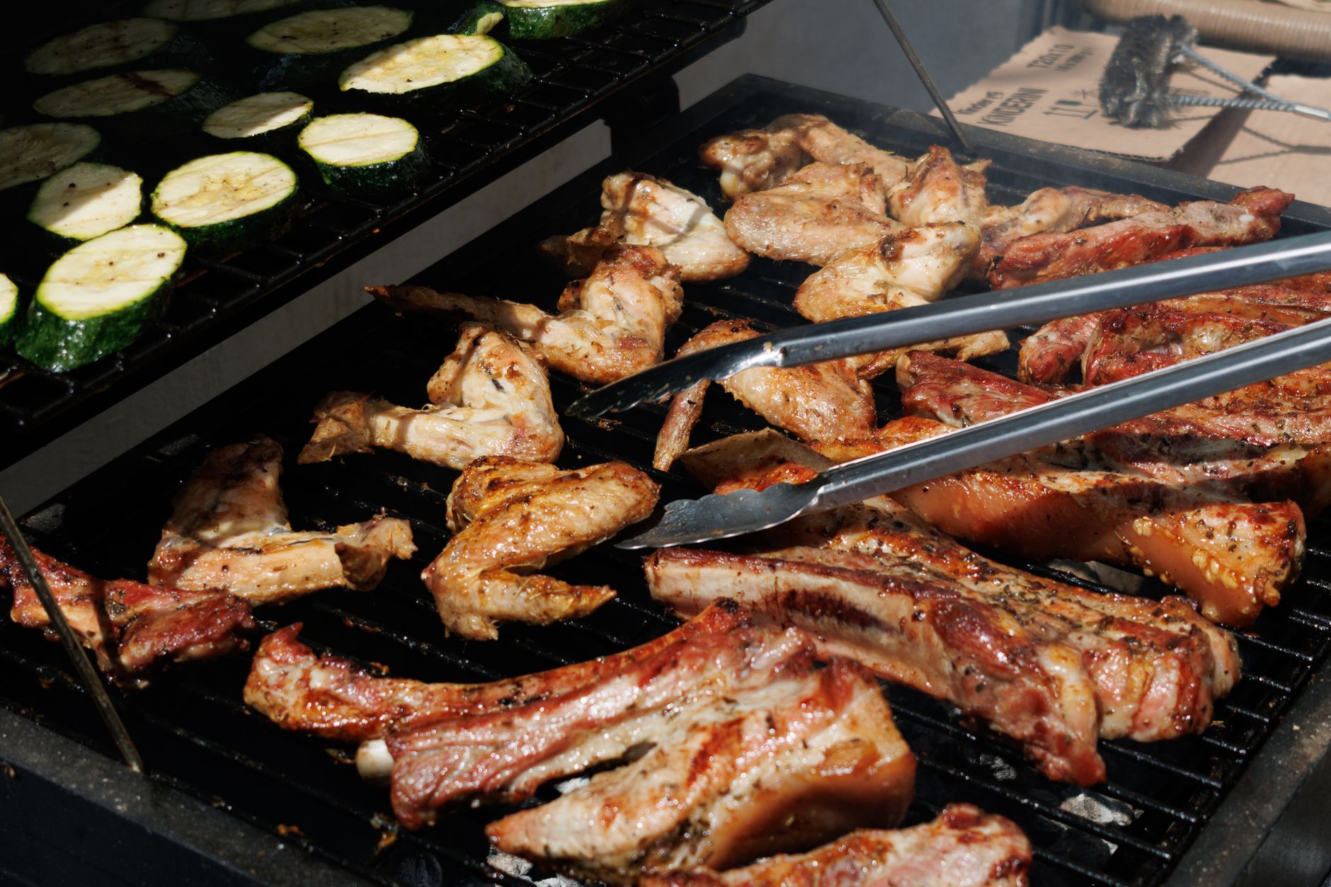 A panoramic view of diverse landscapes, from rugged mountains to coastal plains, with hints of smoke rising from various outdoor cooking scenes, symbolizing global barbecue traditions.