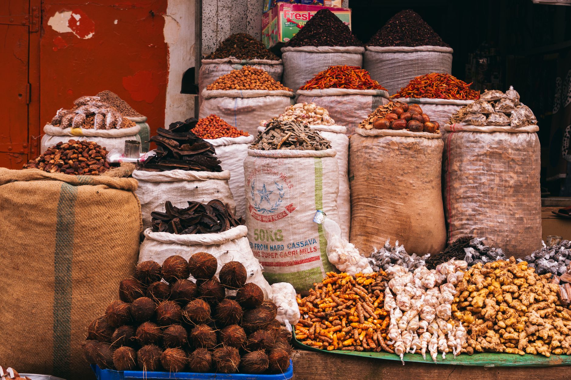 A vibrant, colorful global food market stall brimming with diverse, exotic fruits, vegetables, and spices from around the world, inviting discovery.