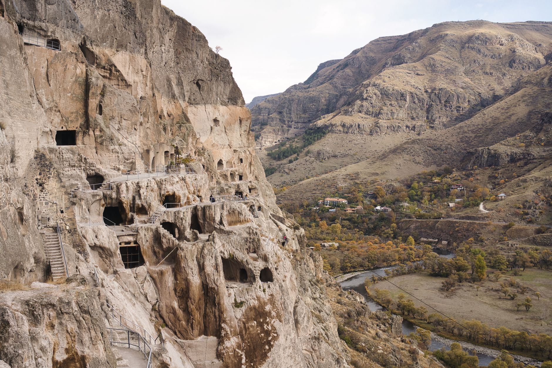 Sweeping view of an ancient, remote rock-hewn city or a mysterious, fog-shrouded landscape, hinting at hidden histories.