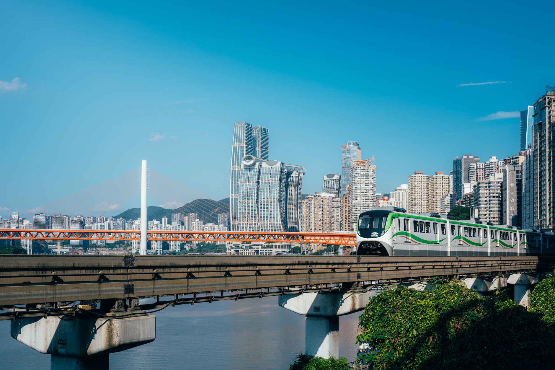 A high-speed train speeding through a lush, mountainous Chinese countryside under a clear sky, with traditional villages nestled in the valleys.