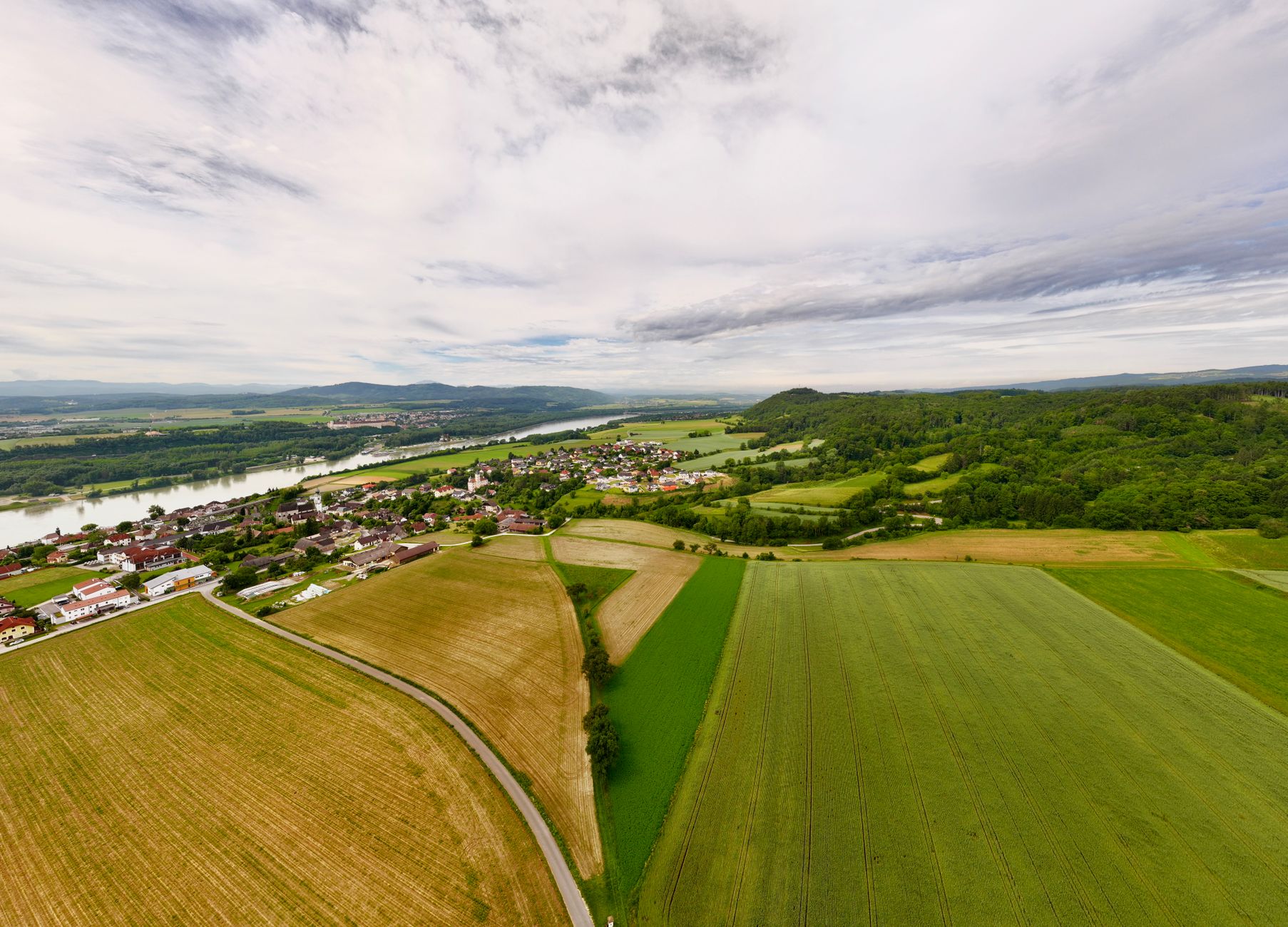 A sweeping panoramic view featuring diverse landscapes – from a green, misty valley to a rugged desert, hinting at the hidden gems and local encounters found in small towns around the world.