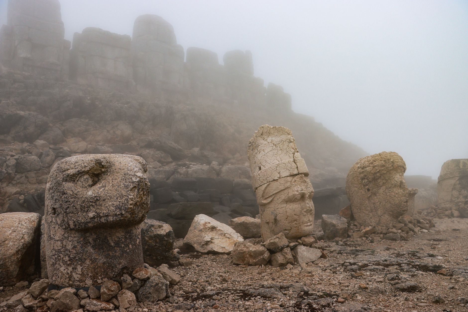 A sweeping vista showing ancient ruins partially covered by lush vegetation, with mist rising from a distant valley, hinting at untold stories of forgotten civilizations.