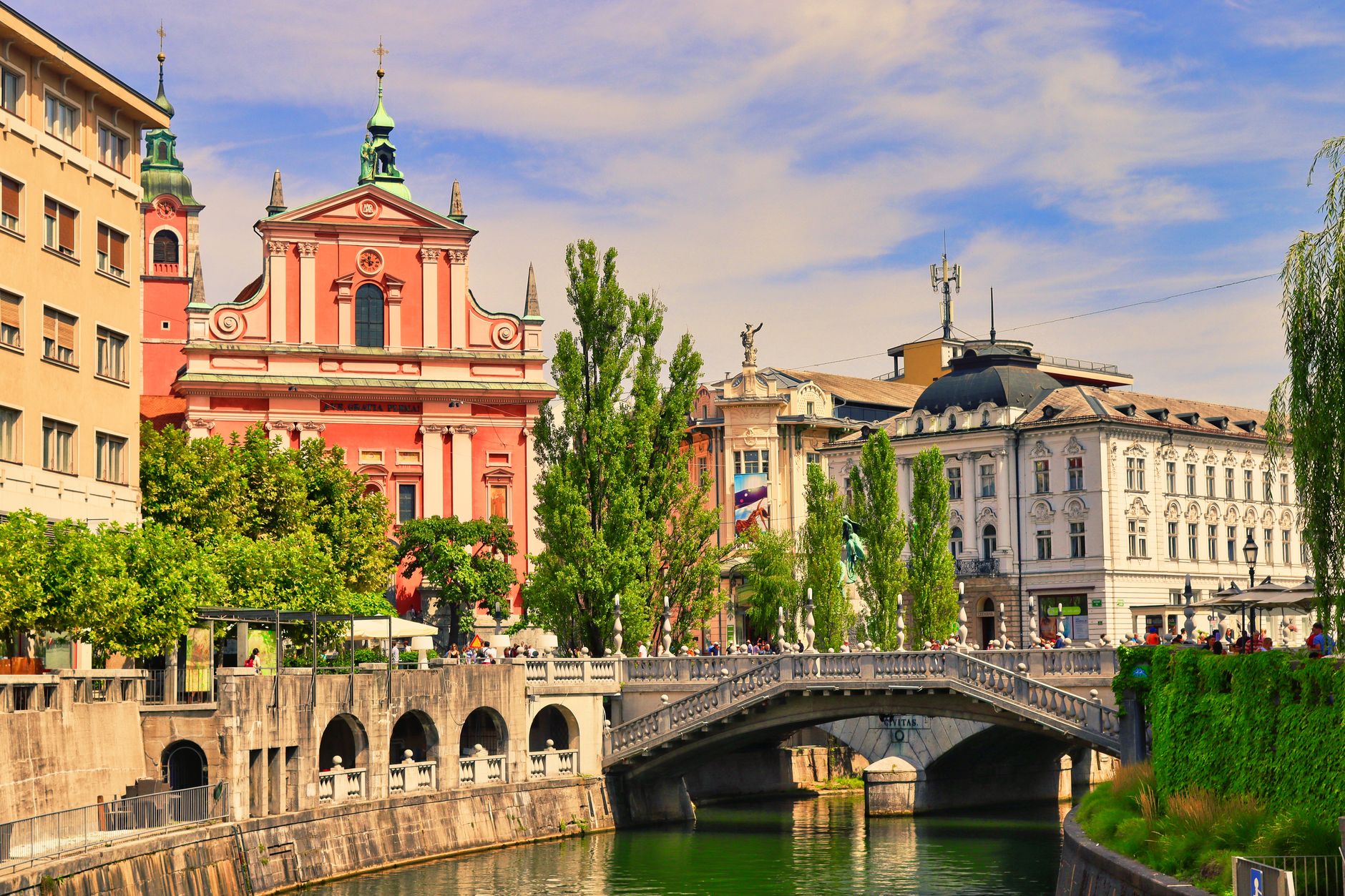Sweeping view of Ljubljana's Old Town, showing the Ljubljanica River and historic buildings, hinting at hidden culinary experiences.