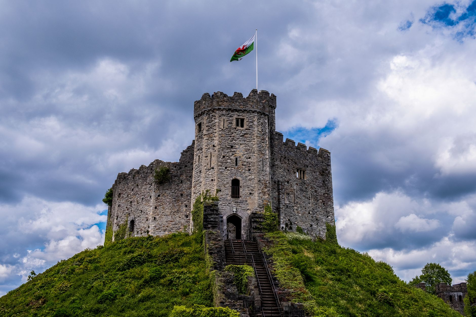 A wide-angle panoramic view of Cardiff city, showcasing a blend of historic Victorian architecture and modern buildings under a dramatic sky.