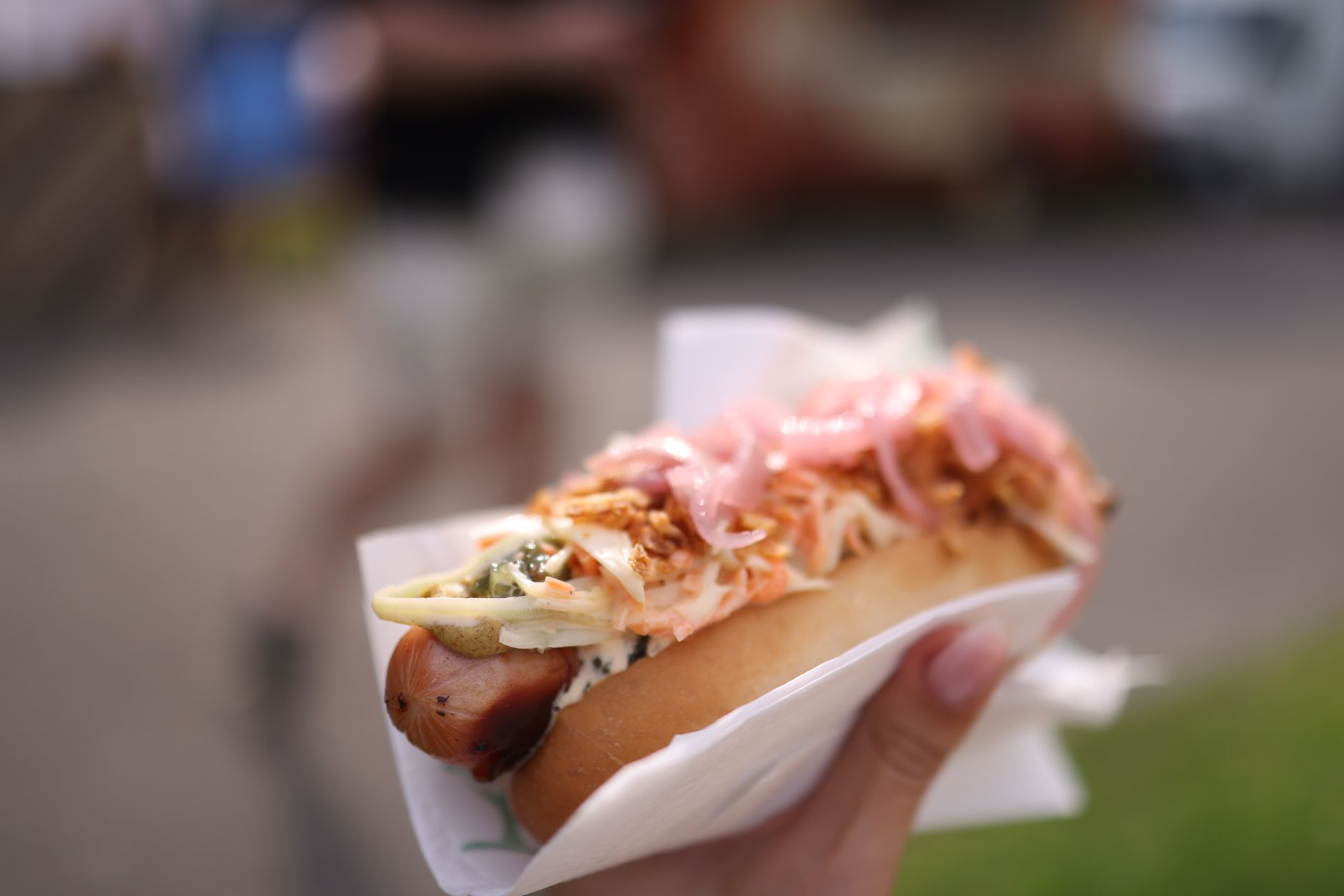 A vibrant, overhead shot of various gourmet hot dogs from different cultures, featuring unique toppings like avocado, tropical relish, and chili, hinting at a global culinary journey.