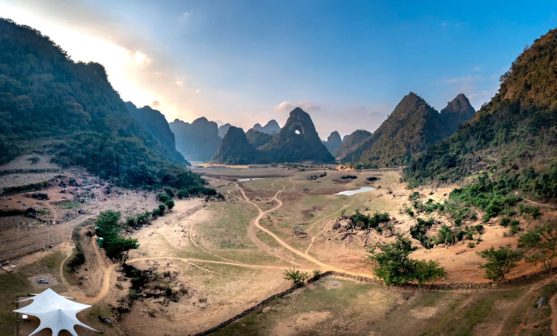A panoramic view of a dramatic, ancient landscape, possibly featuring unusual rock formations or a remote, historic settlement, inviting exploration.