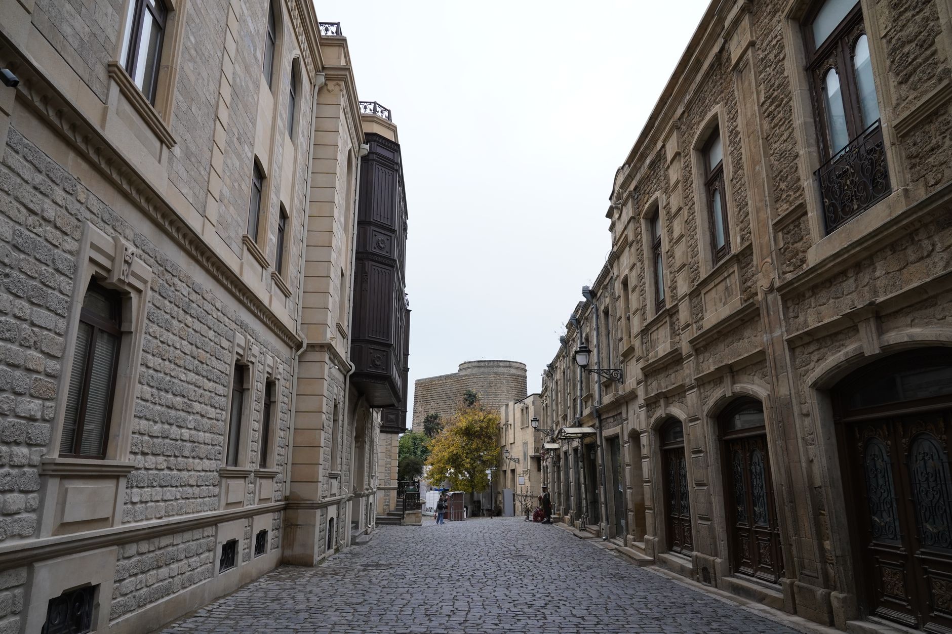 A bustling, sunlit cobblestone street in an old European city, with historic buildings and people enjoying the atmosphere.