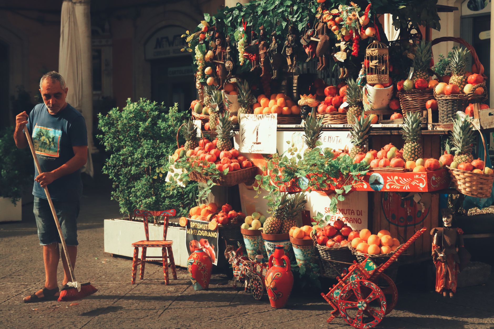 A vibrant, wide-angle shot of a bustling outdoor local market in a foreign country, filled with colorful produce, spices, and people.