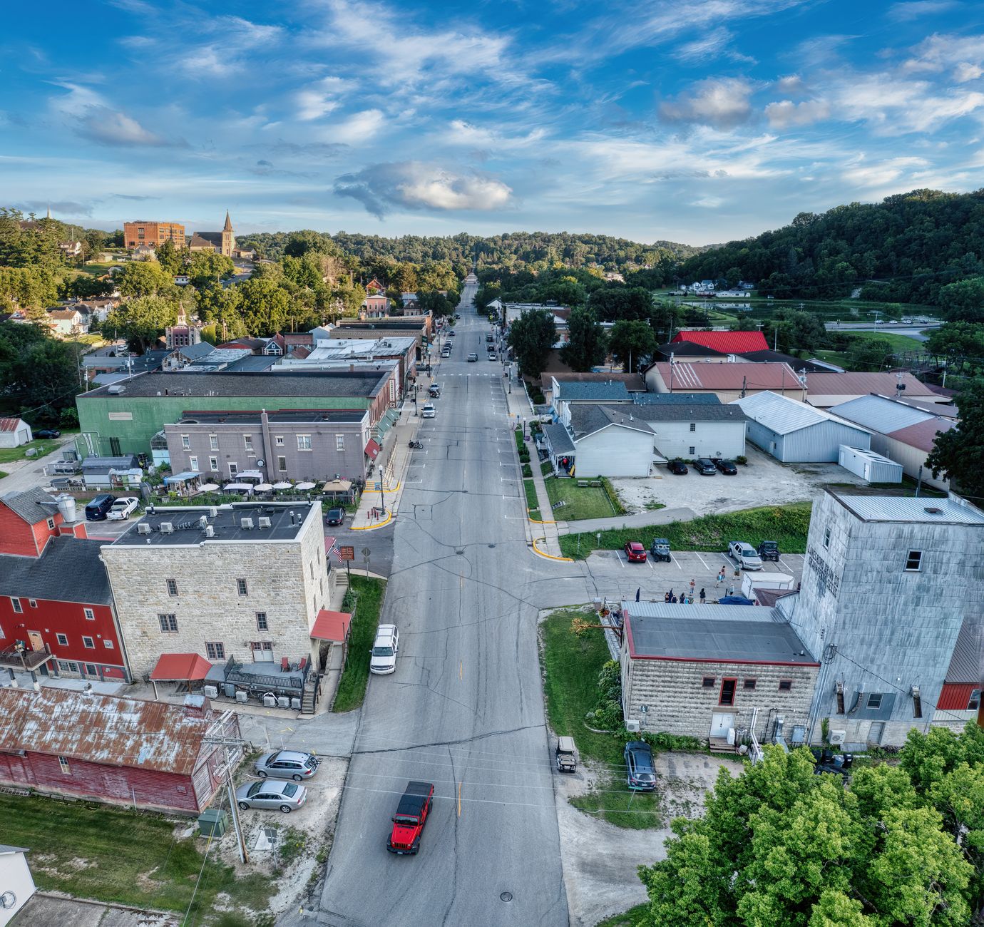 An aerial view of a historic American town with old buildings and winding streets, shrouded in a soft morning mist, evoking a sense of timelessness and hidden stories.