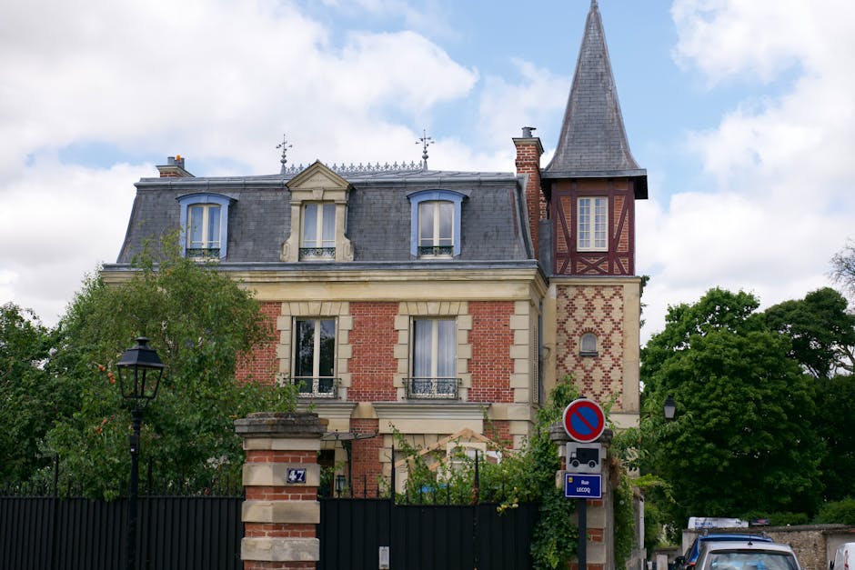 The historic stone facade of Nicolas Flamel's house at 51 Rue de Montmorency in the Marais district of Paris, featuring intricate medieval carvings and arched windows.