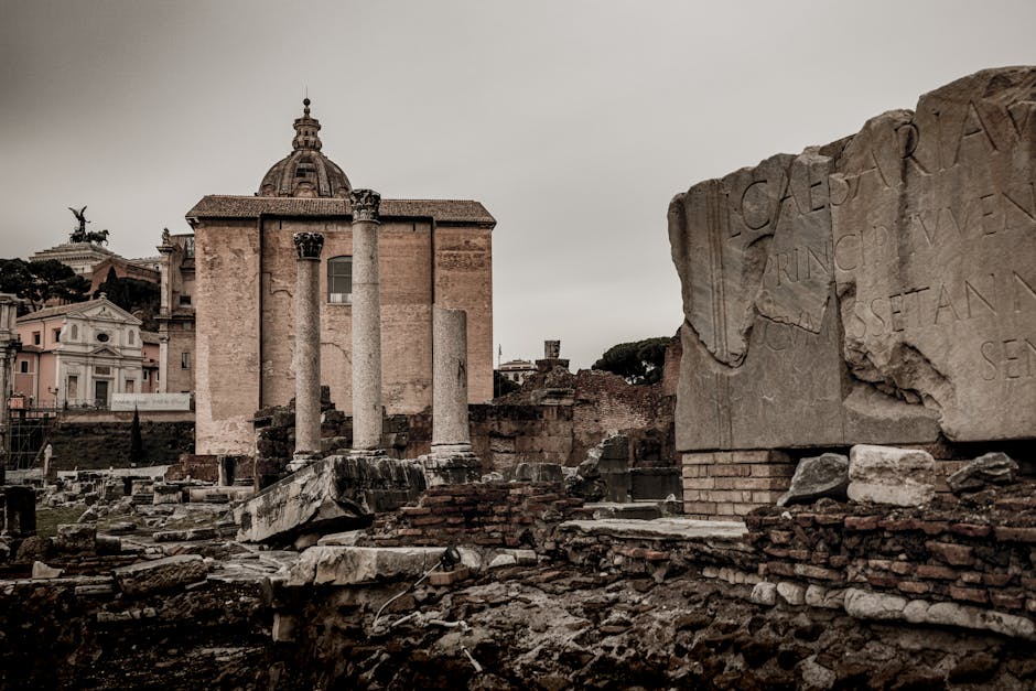 Ancient cypress trees and historic tombstones in Rome's Cimitero Acattolico, with the iconic Pyramid of Cestius visible in the background under a clear sky.