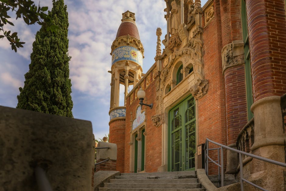 The grand, ornate facade of Sant Pau Recinte Modernista in Barcelona, showcasing its colorful Modernist architecture under a blue sky.