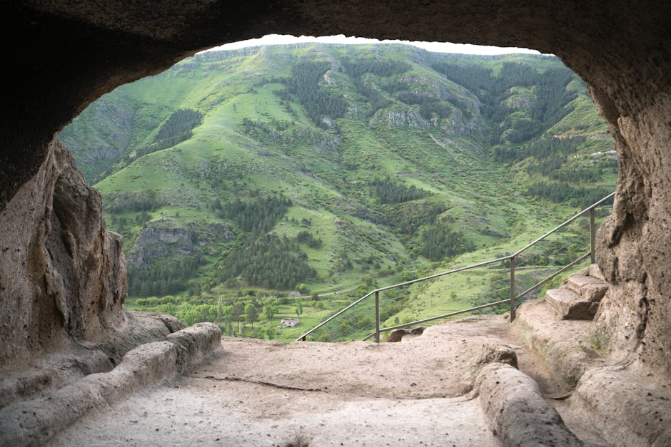 Panoramic view of Vardzia, the ancient cave city carved into a cliff face in Georgia, with its many levels and openings visible against a mountainous landscape.